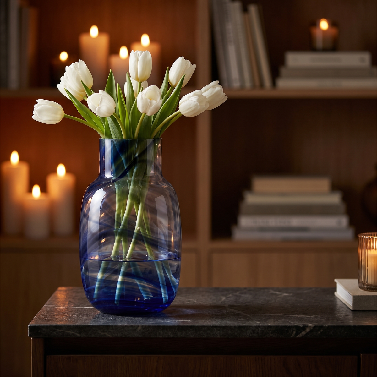 Blauwe Waters vaas met tulpen op een stenen dressoir bij kaarslicht