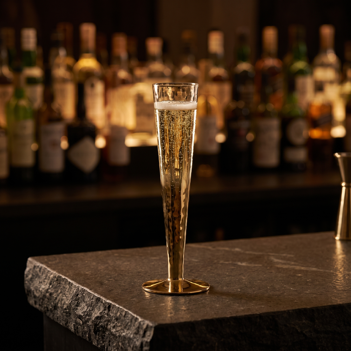 J-Line Champagneglas 15 Cl Goud met champagne op een donkere stenen bar