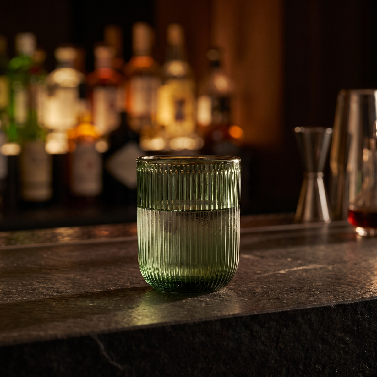 J-Line Waterglas Groen op een donkere stenen bar in de avond